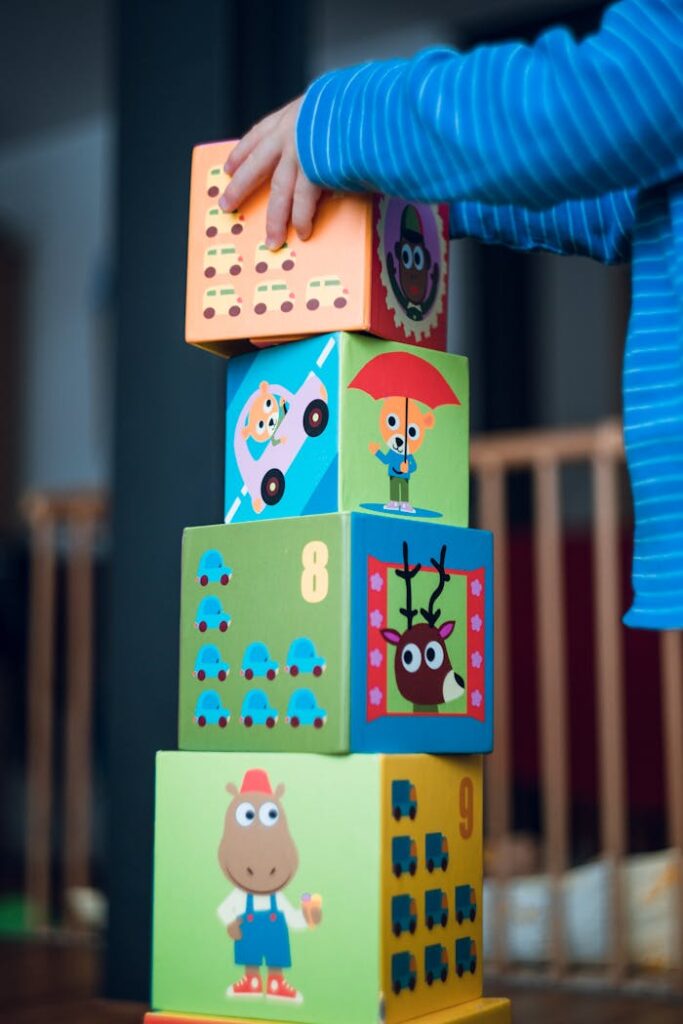 pexels photo 298825 A child playing indoors, stacking colorful wooden toy blocks with joyful illustrations.