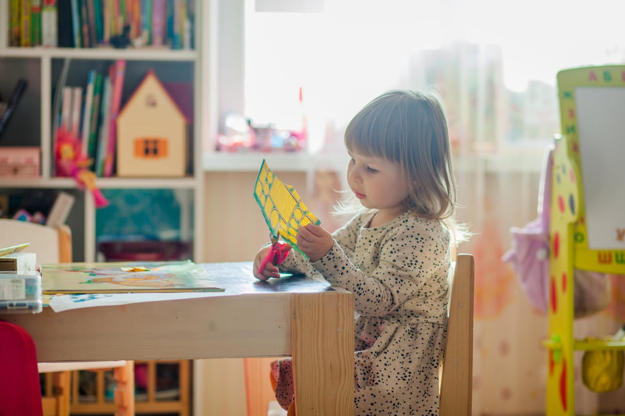 A young girl in a bright classroom engaged in a creative arts and